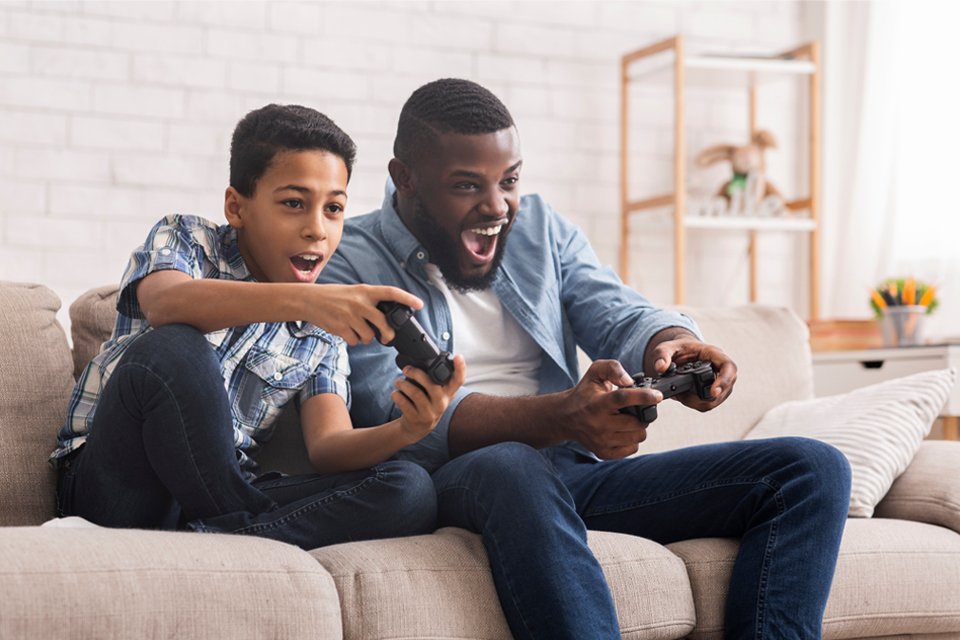 A father and son play video games.